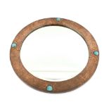 Liberty & Co a copper framed mirror with Ruskin roundels set as flower heads amongst foliage, the