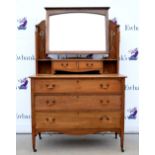 Oak dressing chest, the mirrored top flanked by panelling pierced with stylised tulips, fitted