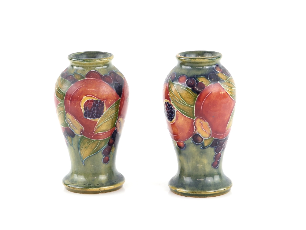 A pair of early Moorcroft vases, pomegranate pattern on a blue ground, painted Moorcroft signature