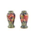 A pair of early Moorcroft vases, pomegranate pattern on a blue ground, painted Moorcroft signature