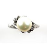 Pearl and diamond twist ring; a cream pearl flanked either side by three graduated old cut diamonds,