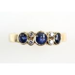 Contemporary sapphire and diamond ring with three sapphires in rub over setting, and two brilliant