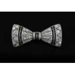 An Art Deco diamond and onyx bow brooch, millgrain set with transition cut stones, and channel set