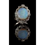 1950's opal and diamond ring, set with an oval opal, with four round brilliant cut diamonds set in