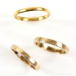 Three gold wedding bands, one 22 ct, ring size R half and two matching, stamped 14 ct, both size O