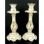 Pair of 19th Century Coalport candlesticks, decorated with flowers and highlighted in gilt, 26 cm.