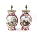 Pair of German porcelain lamp bases, the puce ground with panels of waring figures, Augustus Rex