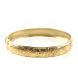 Gold oval hinged bangle, floral detailing, with figure of eight safety catch, stamped 9 ct Being