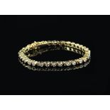 Diamond line bracelet, set with thirty four rub over set round brilliant cut diamonds, estimated