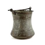 A Persian metal bucket with loop handle and pie-crust rim; decorated on the exterior with a