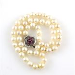 A cultured pearl necklace with pearls of 7-8 mm to a ruby set white metal clasp, testing as 9 ct
