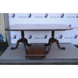 20th century mahogany twin pedestal dining table, columns on carved trefoil bases, with extra leaf,.