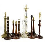 Six turned wood table lamps, thermometer stand, two brass lamps, glass lamp with hanging drops and a
