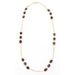 Rhodolite garnet necklace, set with eighteen oval and pear cut faceted garnets linked by gold chain,