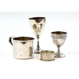 Selection of silver to include an egg cup, trophy cup, mug and a napkin ring (4).