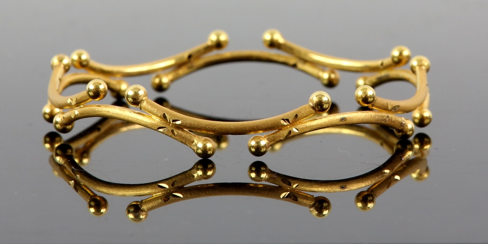 Gold bangle, made up of a series of curved sections with spherical terminations, brushed finish,