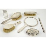 George V silver backed mirror, three brushes, a mount for a comb, a shaped box and a glass bottle