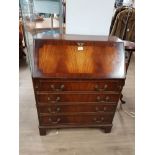 A FOUR DRAWER BUREAU WITH BRASS HANDLES AN LEATHER INSERT