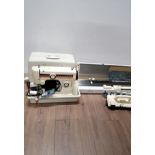 A NEW HOME SEWING MACHINE IN CARRY CASE WITH ACCESSORIES