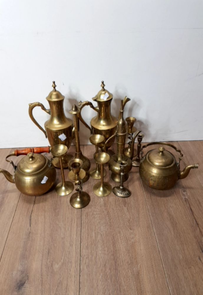 A QUANTITY OF EASTERN BRASS TEAPOTS AND CANDLE STICKS