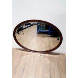 AN BEVELLED SHAPED MAHOGANY MIRROR