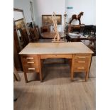 AN OAK SEVEN DRAWER TWIN PEDESTAL WRITING DESK