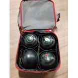 A BAG CONTAINING LAWN GREEN BOWLS