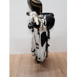 A GOLF BAG CONTAINING CLUBS 2 LEFT HANDED GLOVES AND TEES ETC