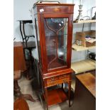 A SLIMLINE MAHOGANY DISPLAY CABINET WITH SHELL MOTIF