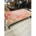 A LARGE POUFFE WITH BRASS CASTERS