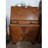 HEAVILY CARVED OAK BUREAU WITH LEATHER INSERT