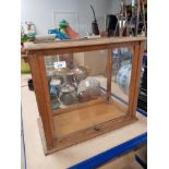 A TABLE TOPPED DISPLAY CABINET WITH SLIDING FRONT