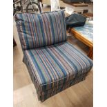 A FOLDING BED CHAIR IN A STRIPED FABRIC