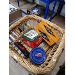 A WICKER BASKET CONTAINING OLD TINS