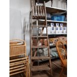 A SET OF TALL WOODEN LADDERS