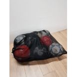 A NETTED BAG CONTAINING FOOTBALLS