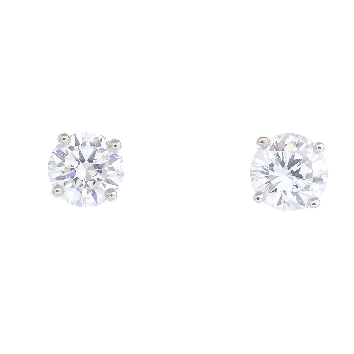 A pair of brilliant-cut diamond stud earrings.