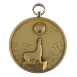 An early 20th century gold sea lion medallion.