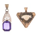 Two gem-set pendants.