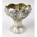 A German silver vase of wrythen and fluted form with wide scalloped rim and embossed fruit panels