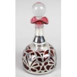An early 20th century cranberry glass and silver overlaid scent bottle and stopper,