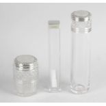 A clear glass vanity jar of long cylindrical form with diamond cut band and a smaller,