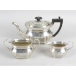 A late Victorian silver three piece bachelor tea service,