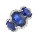 A sapphire three-stone and diamond ring.