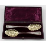 A cased pair of George II silver 'berry' spoons,