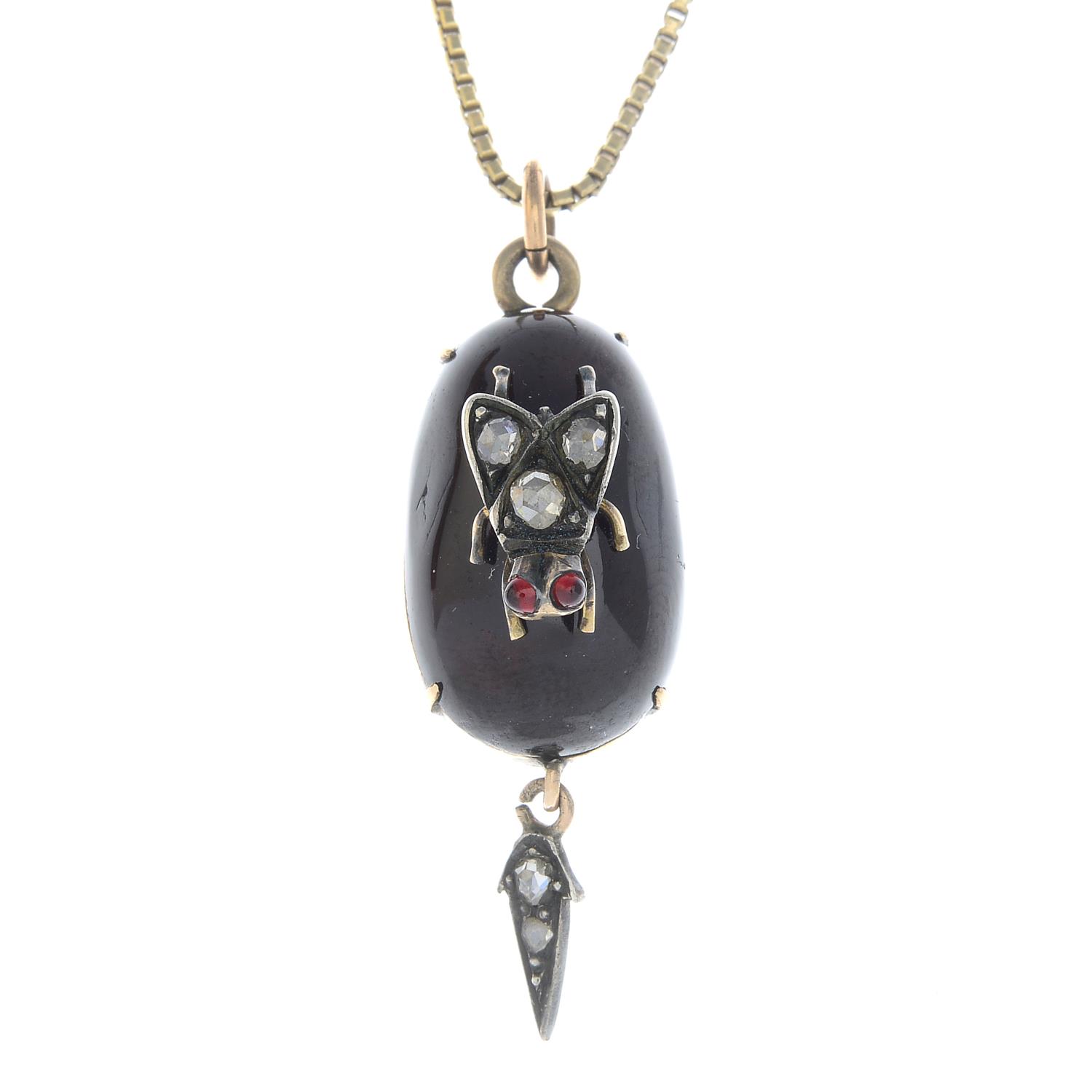 A garnet and diamond insect pendant.