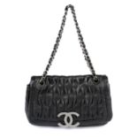 CHANEL - a black perforated leather single flap handbag.