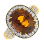 A brownish-orange topaz and diamond cluster ring.Topaz calculated weight 6.31cts,