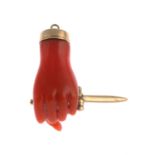 A late 19th century gold coral Figa charm, grabbing a dagger.