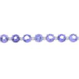 A tanzanite and diamond line bracelet.Tanzanite total weight 17.10cts.Total diamond weight